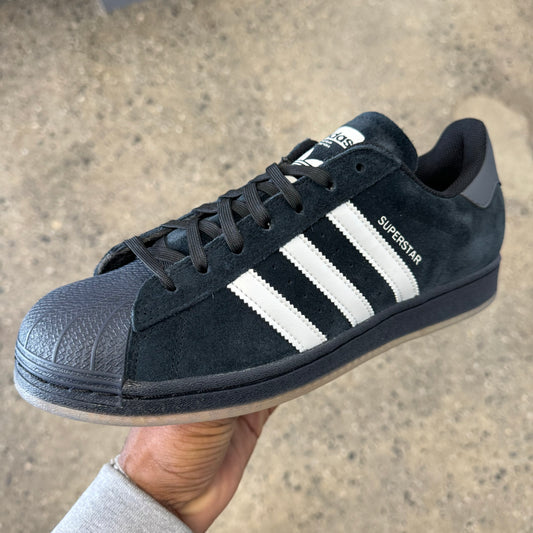 black suede sneaker with white stripes, side view