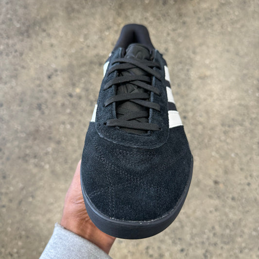 black suede sneaker with white stripes and black sole, front view