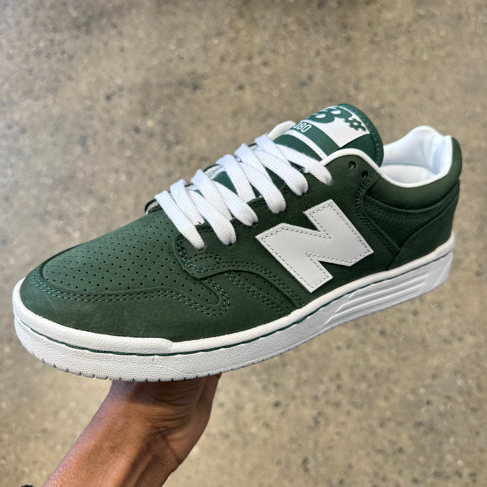 green suede sneaker with white N and white sole, side view