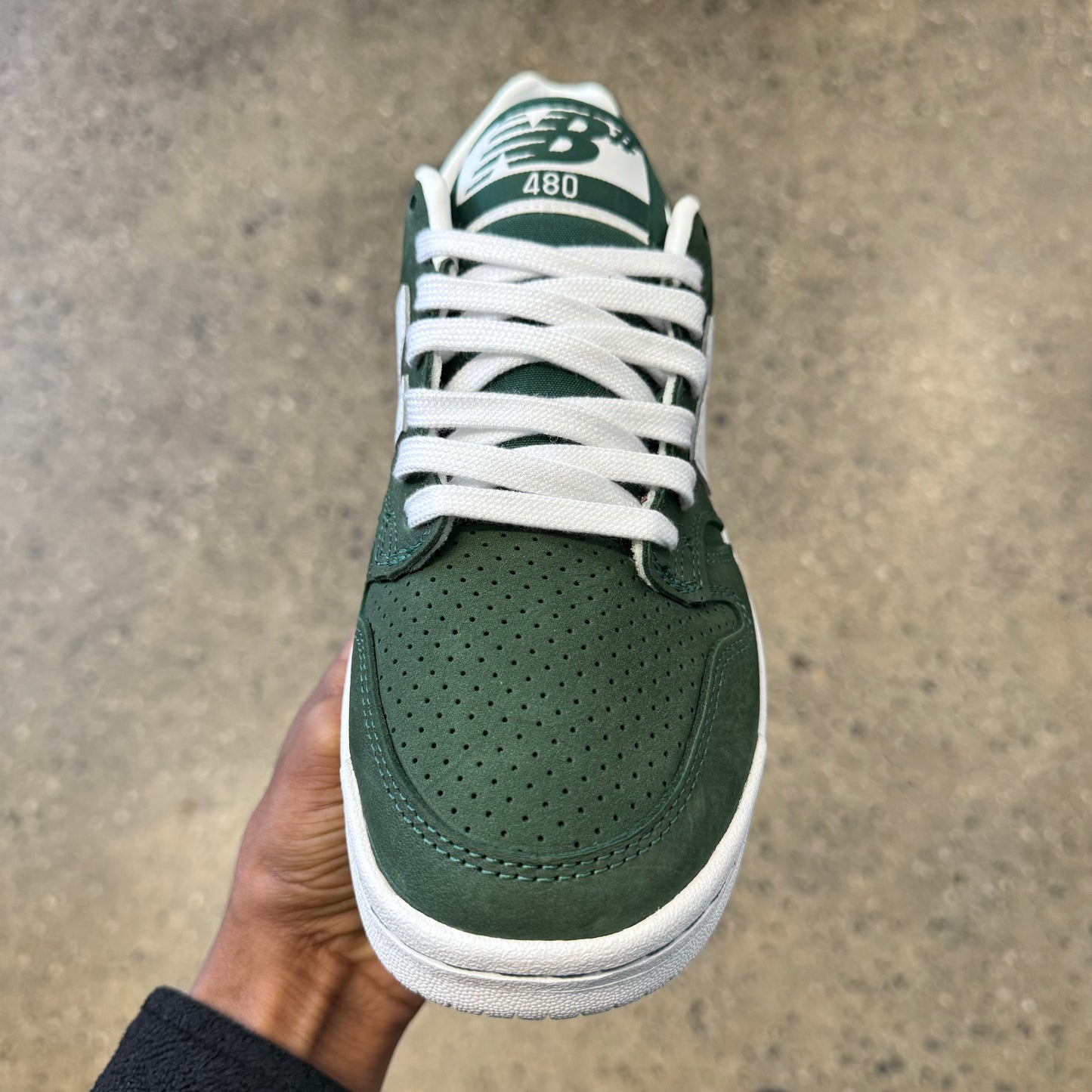 green suede sneaker with white N and white sole, front view
