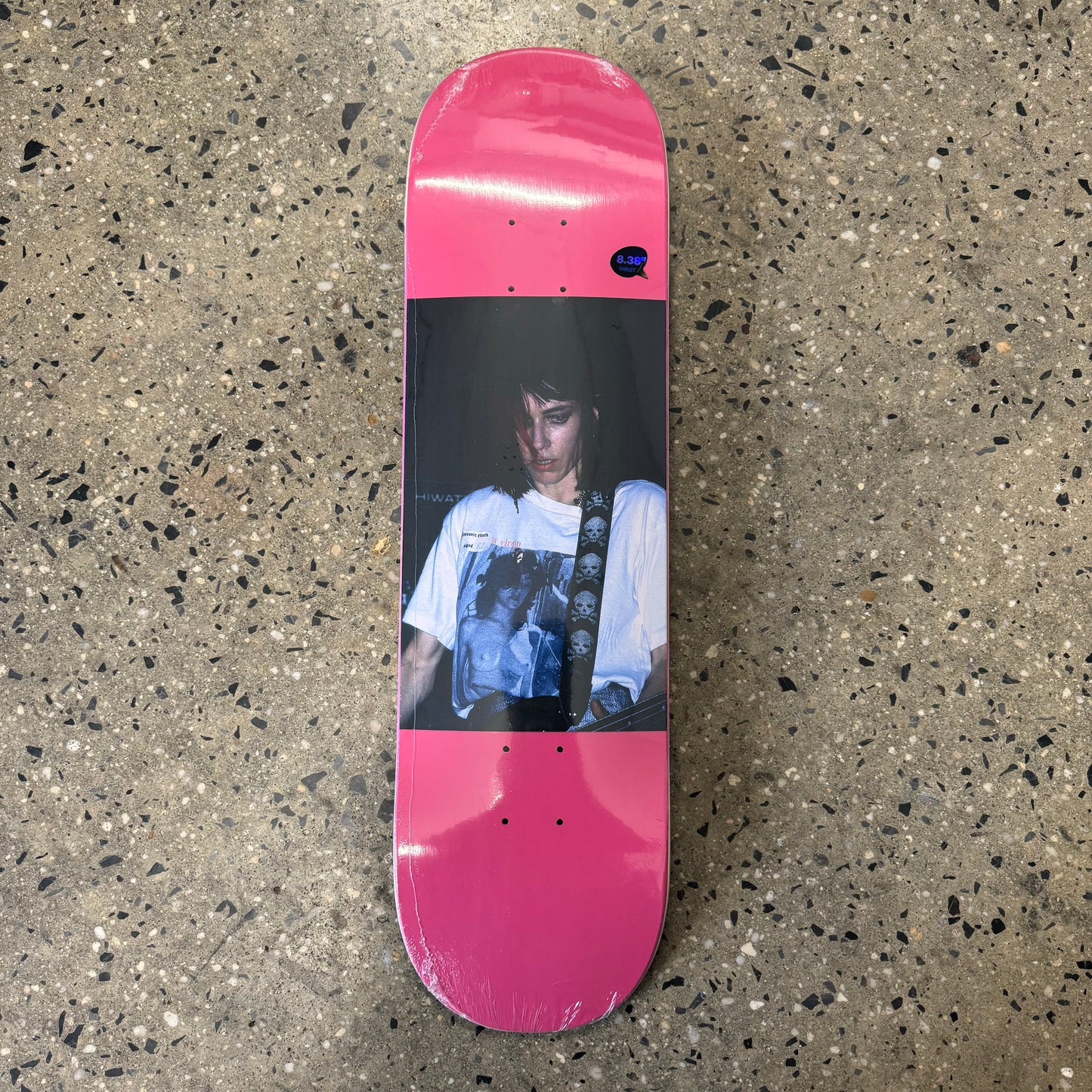 girl playing guitar on pink skate deck