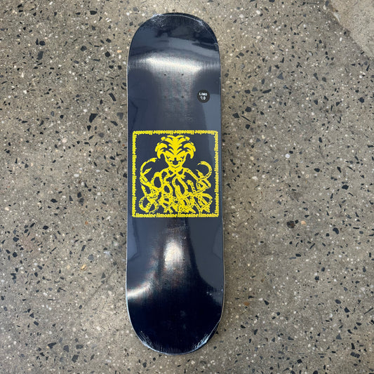 yellow snakepit graphic, man with snakes underneath him on black skate deck