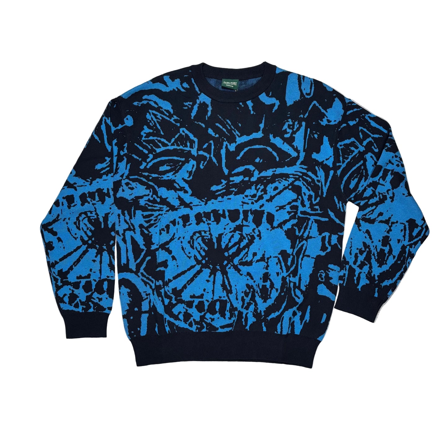 Blue and black patterned sweater on a white surface