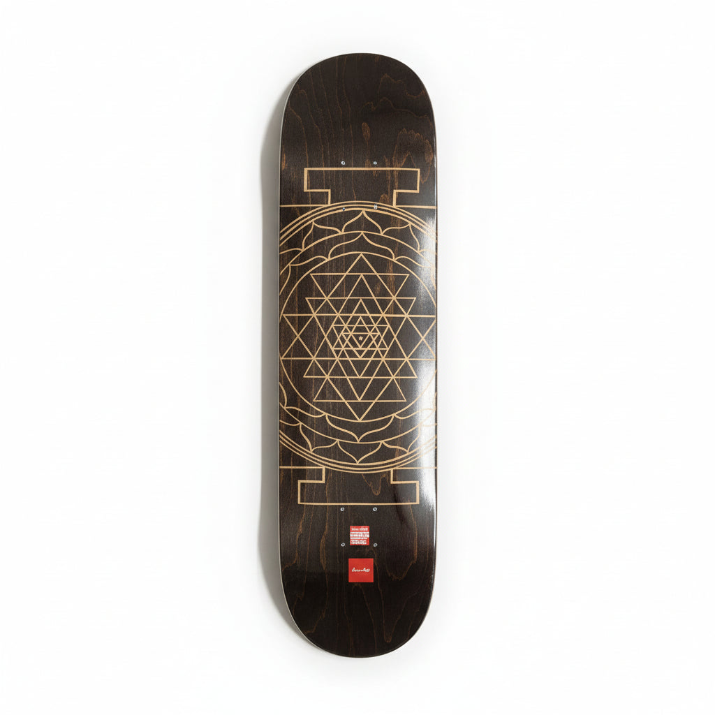 Skateboard deck with geometric mandala design on a white surface