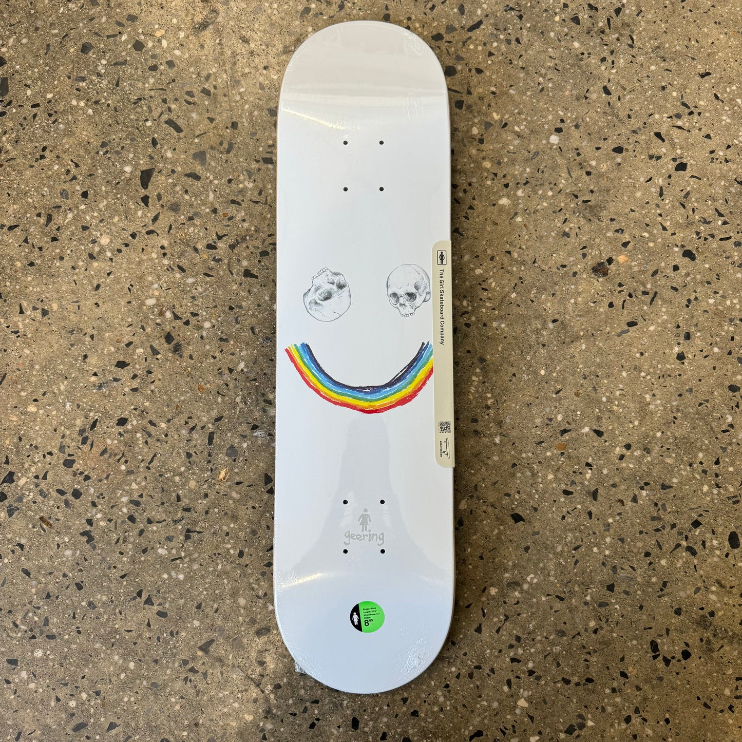 two skull heads and rainbow on white skate deck