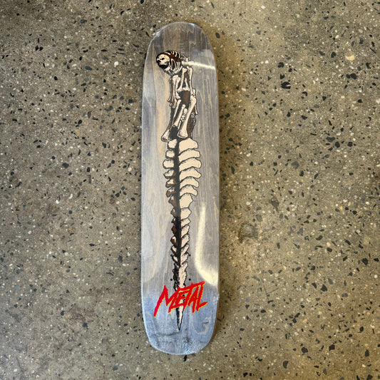 woodgrain deck with a dagger in the shape of a extra terrestrial spine in the center