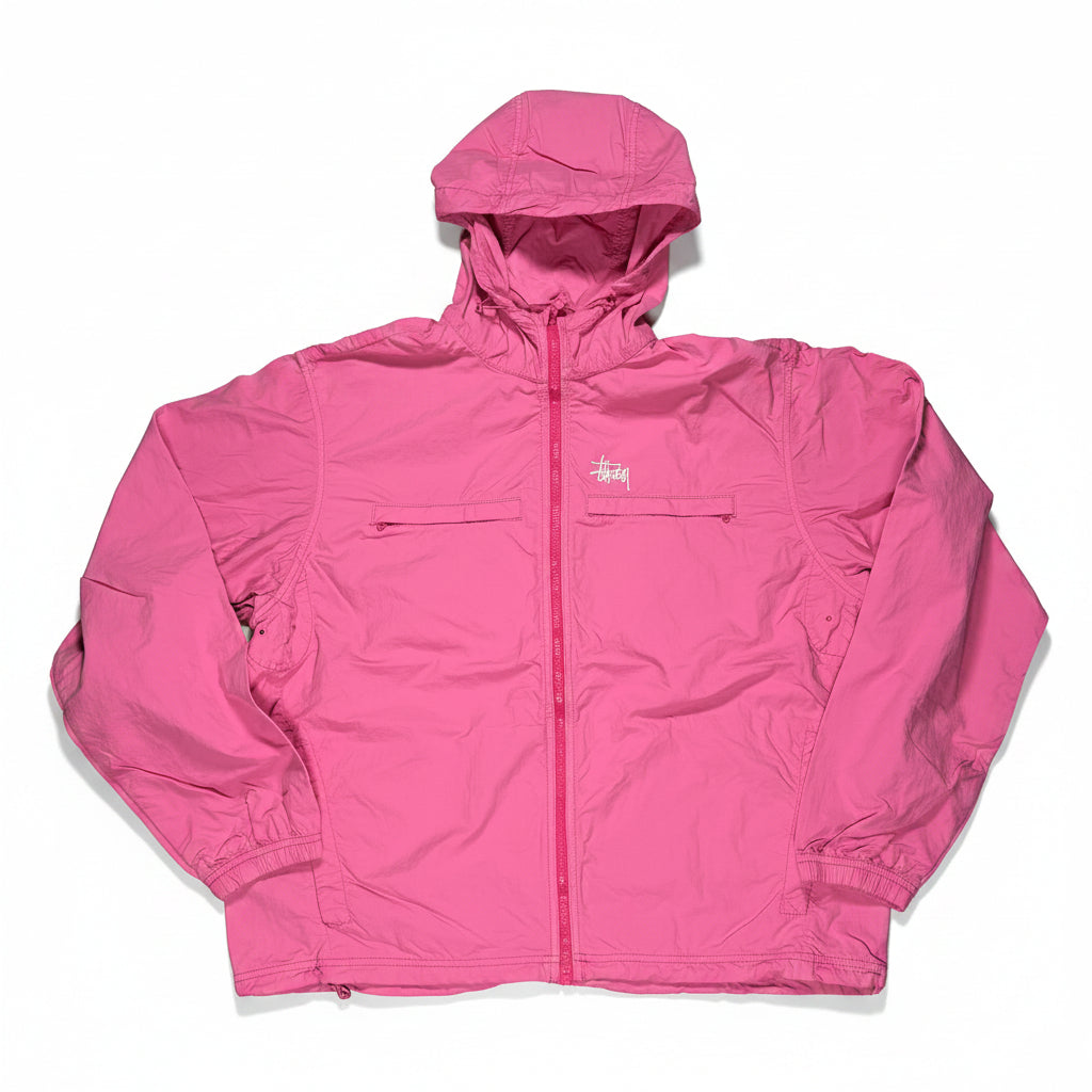 Pink jacket on a white surface with a visible stussy brand logo.