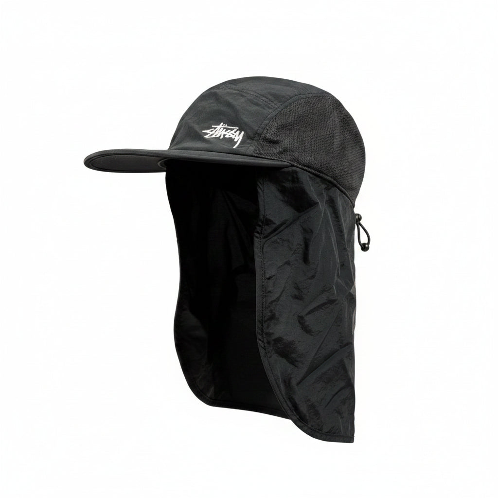 Black cap with a stussy brand logo on a white surface