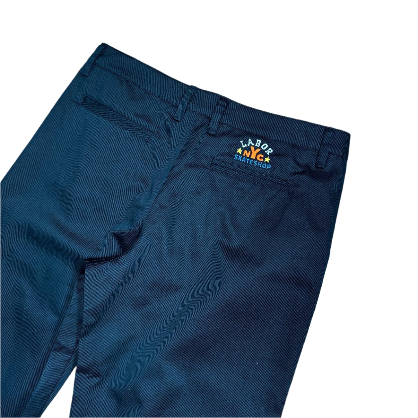 close up view of black chino pant with embroidery above right pocket