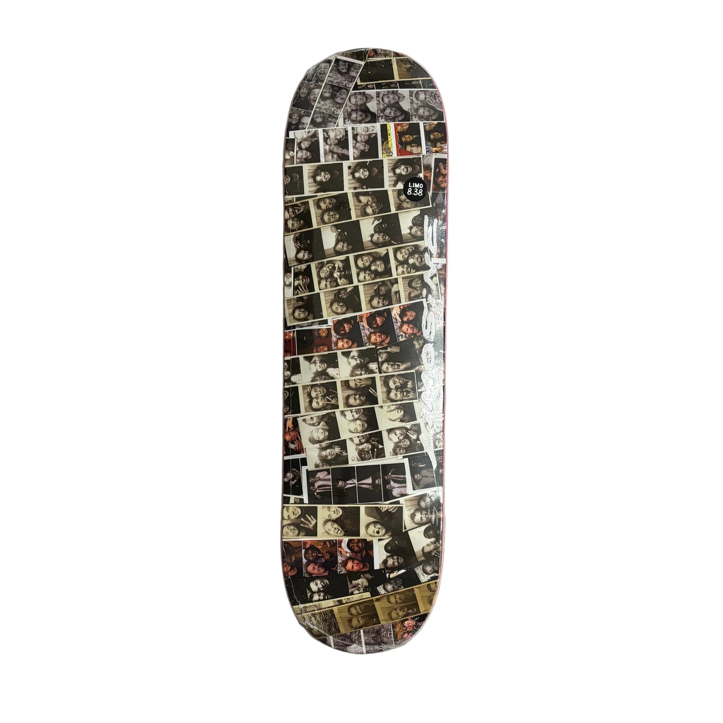 A skateboard deck featuring a collage print of numerous black and white portrait photographs, on a white surface