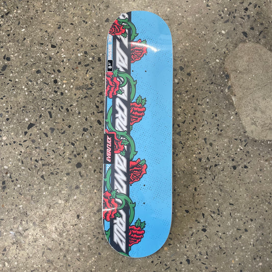 black and white logo with red roses on light blue skate deck