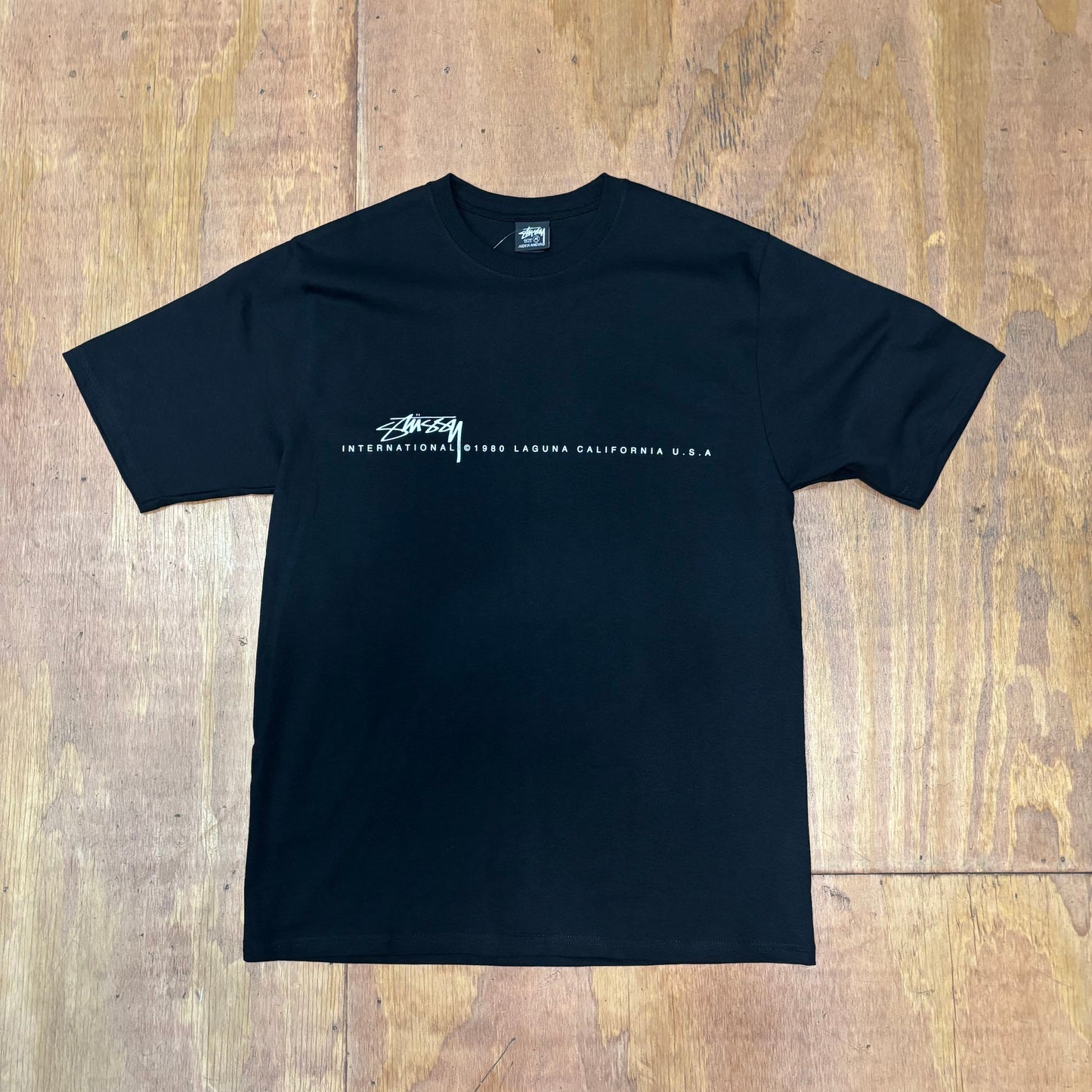 black t-shirt with STUSSY INTERNATIONAL printed across the front