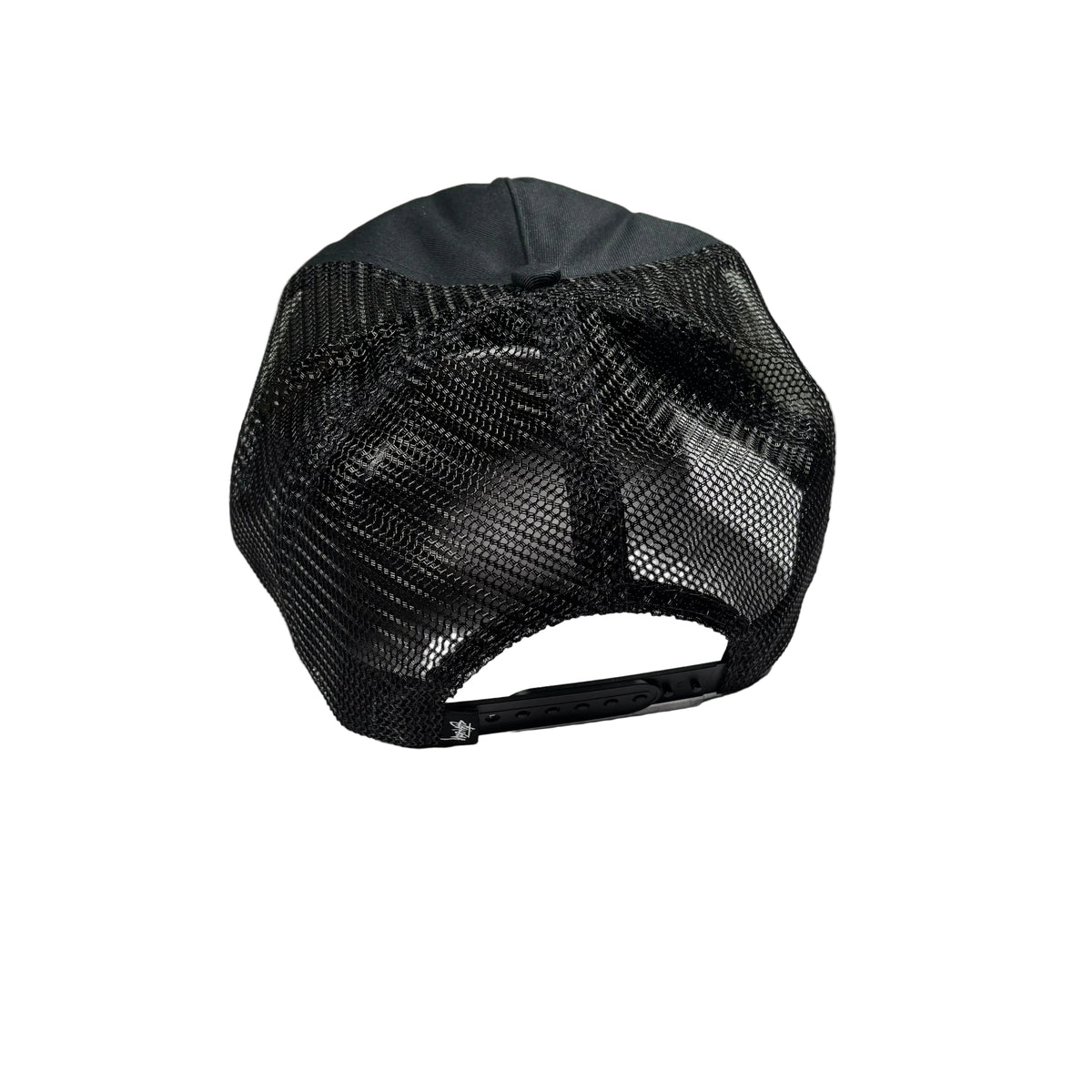 A black trucker-style baseball cap with a black mesh back, photographed from above on a white surface.