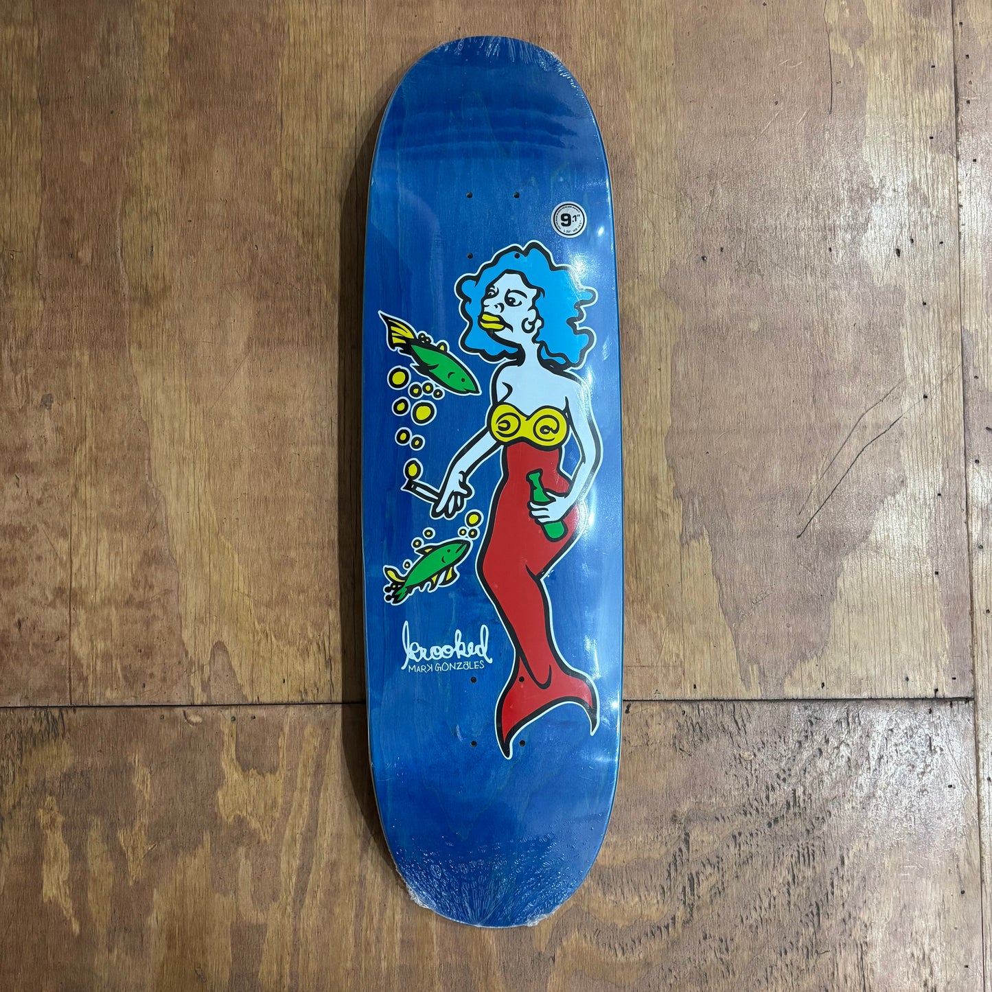 hand drawn mermaid on woodgrain graphic football shaped skateboard deck