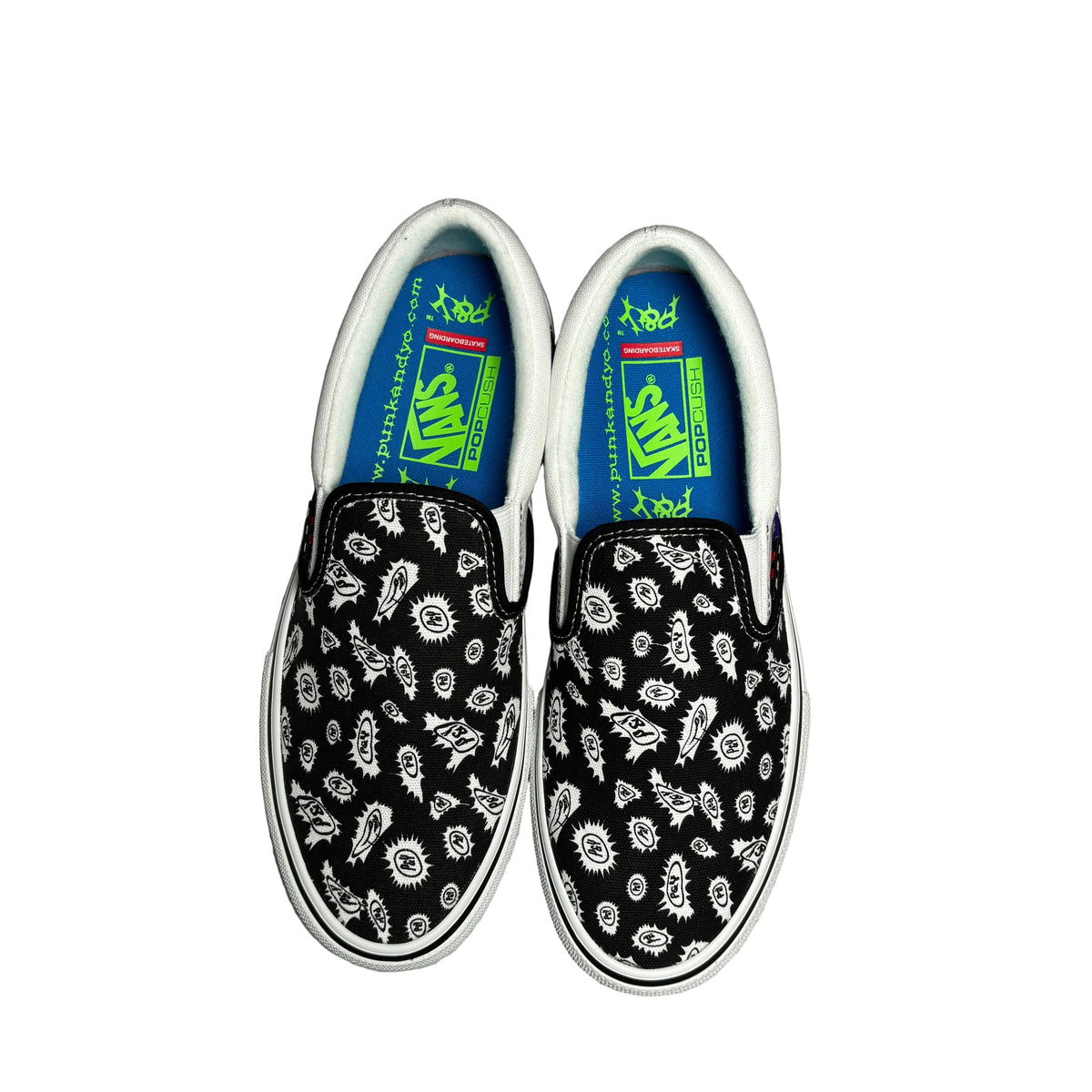 Top view of black and white slip on sneakers with a blue lining. Displayed on a white background.