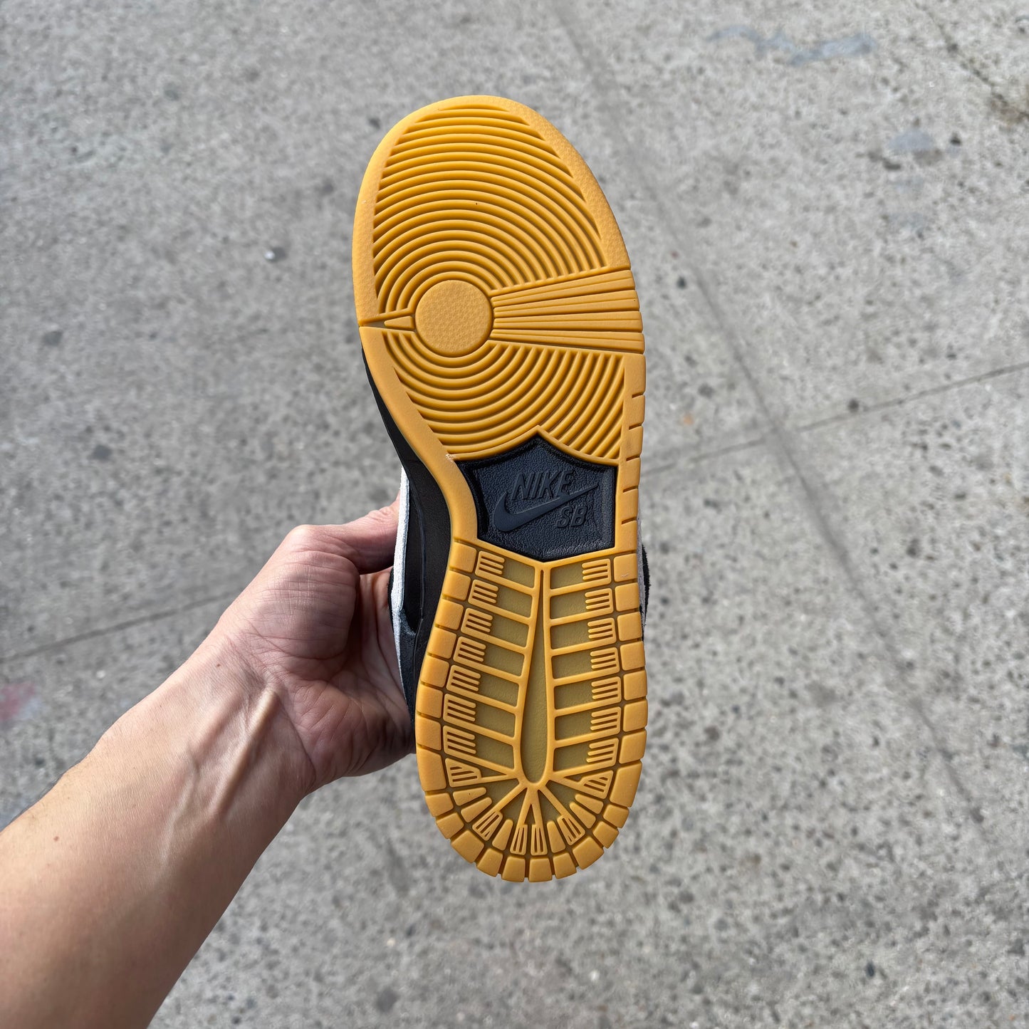 view of gum rubber outsole on black/white nike sb dunk low