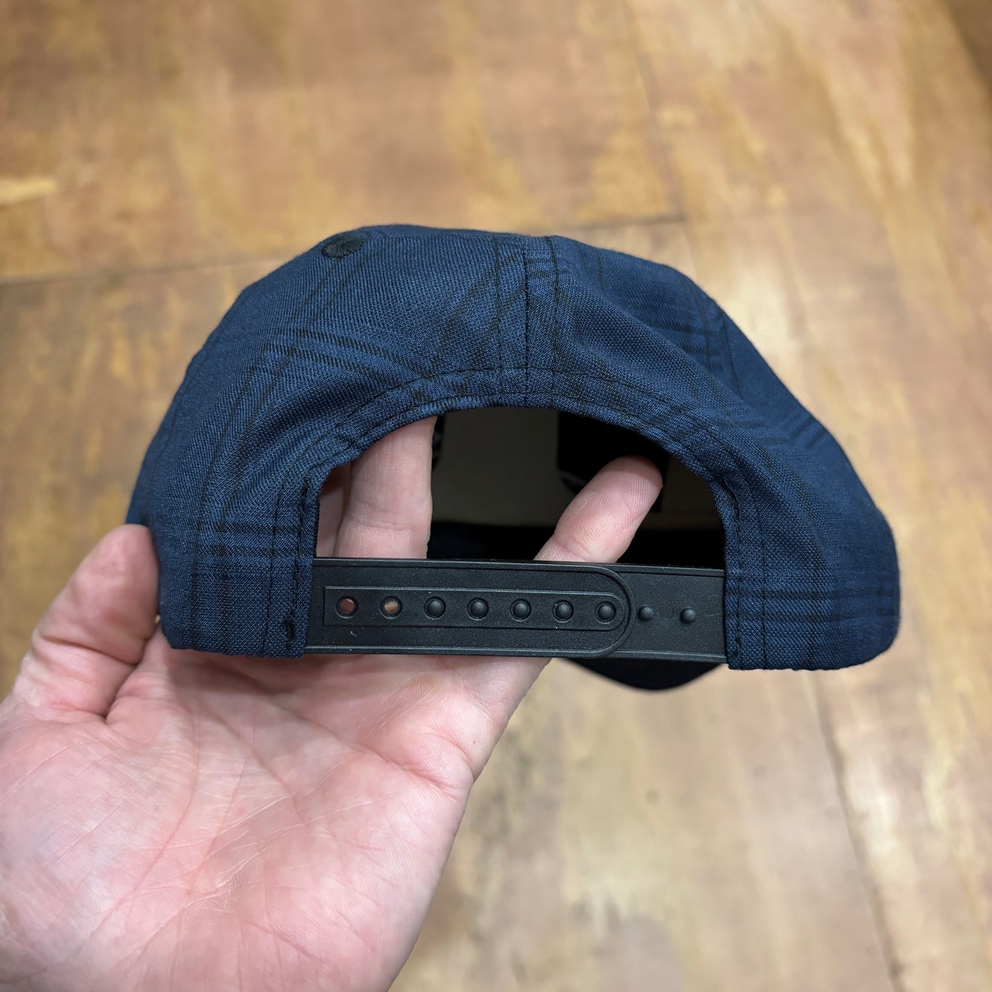 view of rear of navy blue snapback cap with snap closure