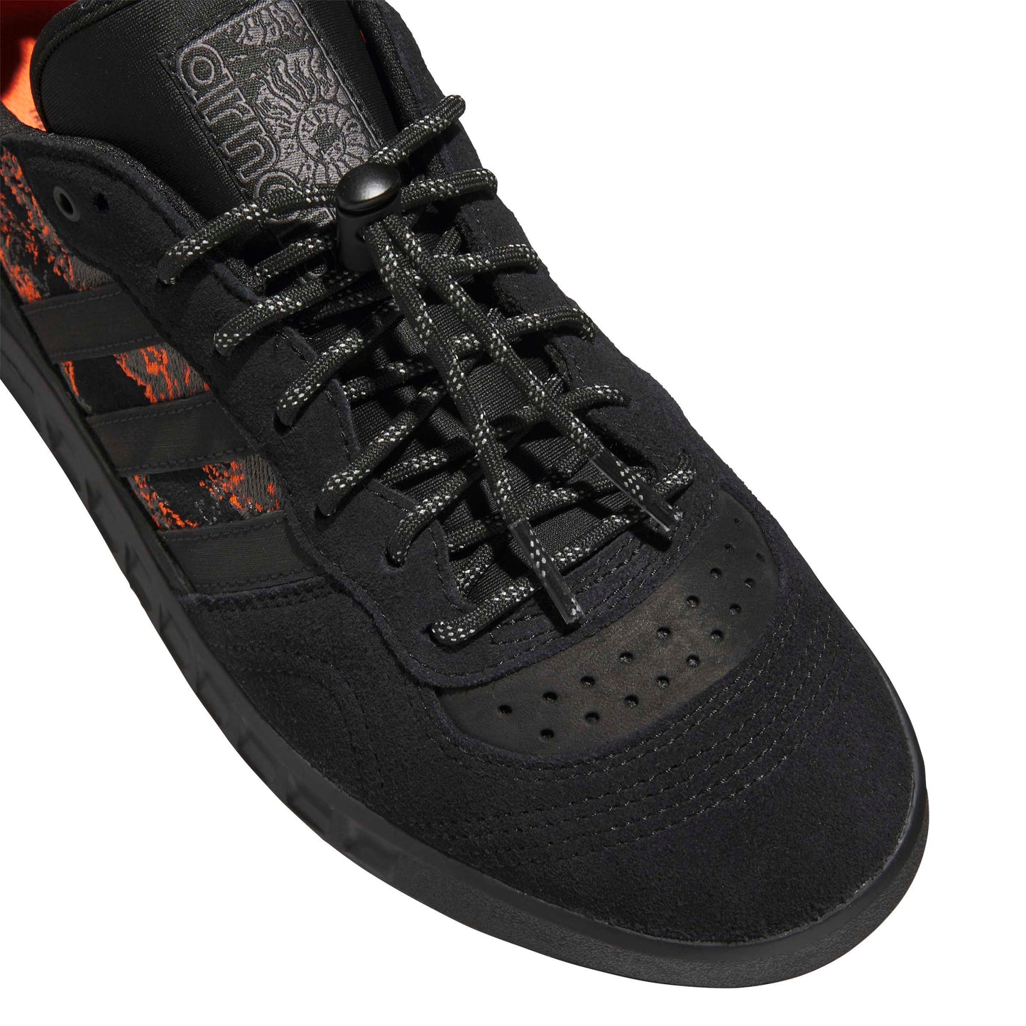 Black sneaker with orange accents on a white background
