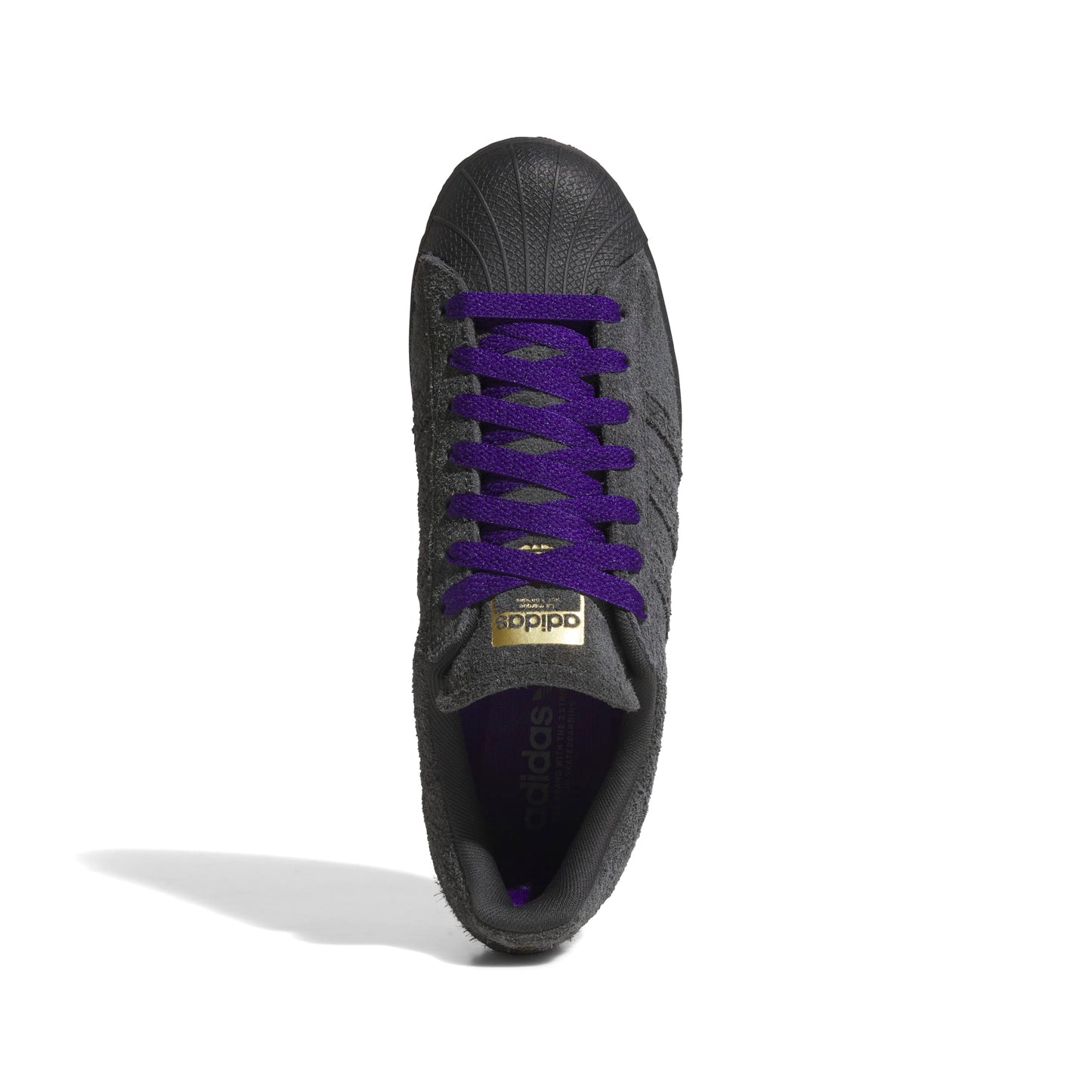 Black Adidas sneaker with purple laces on a white background