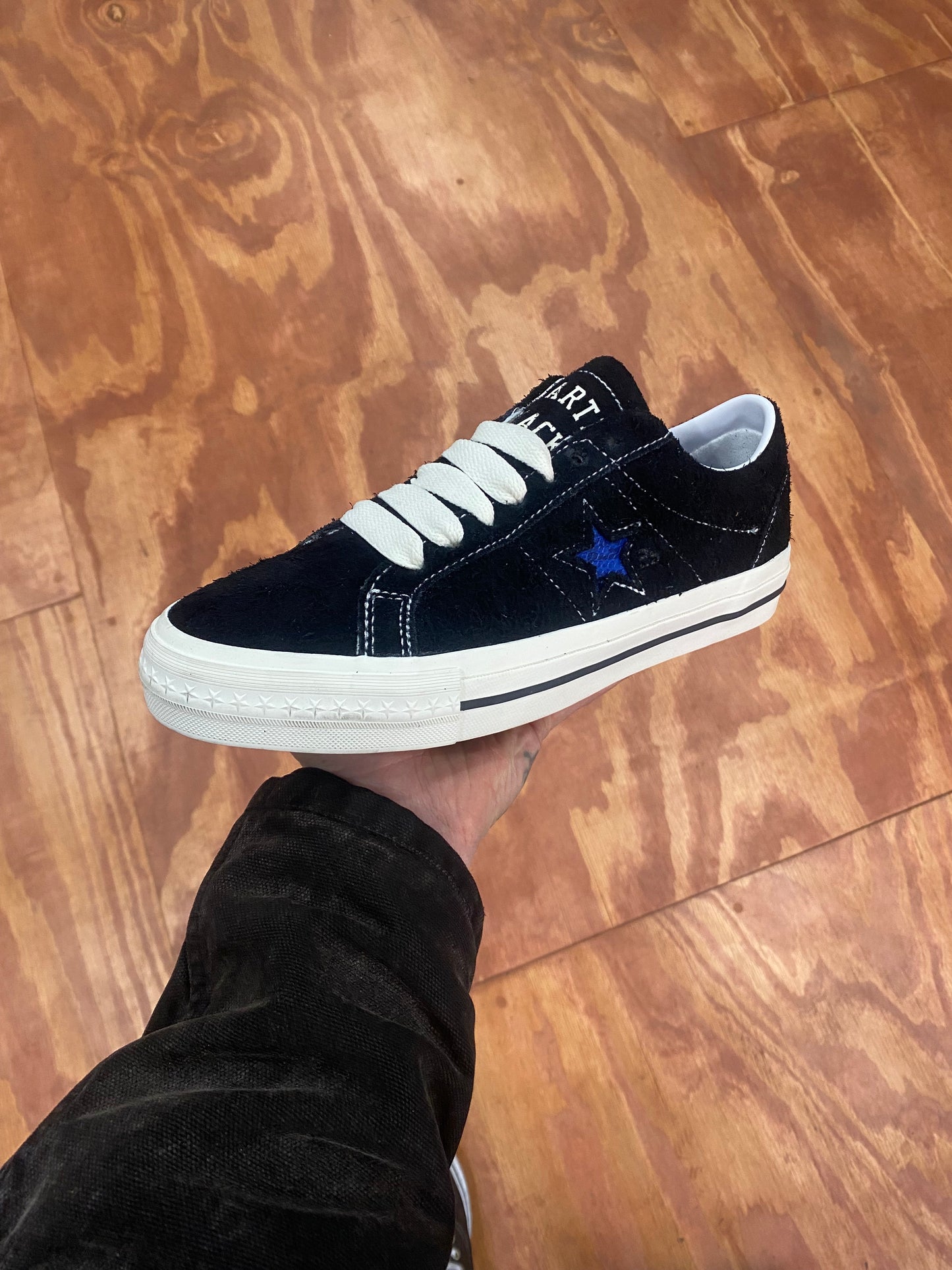 black suede sneaker with blue star, white sole and stitch