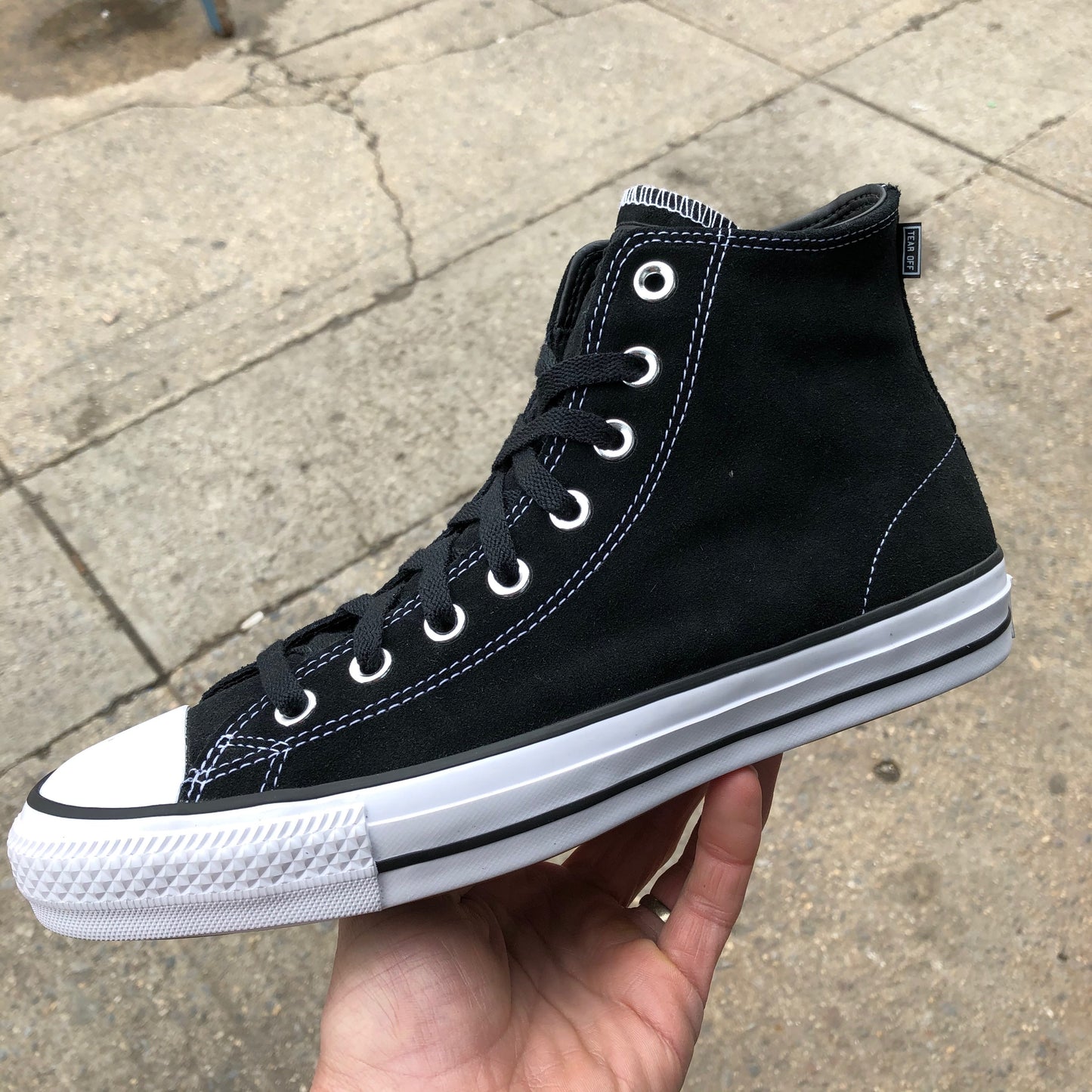 black hi top sneaker with white sole and toe, side view