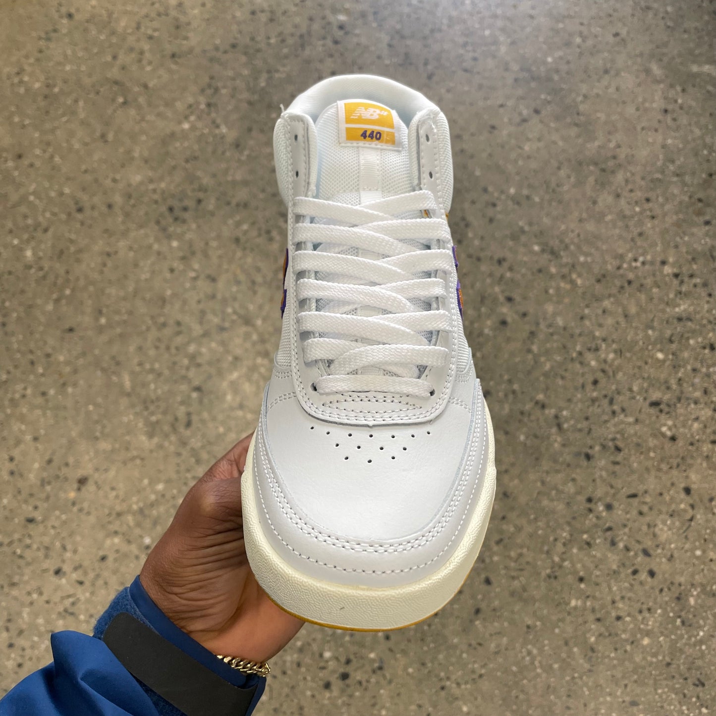 white hi top sneaker with yellow N and white sole, front view