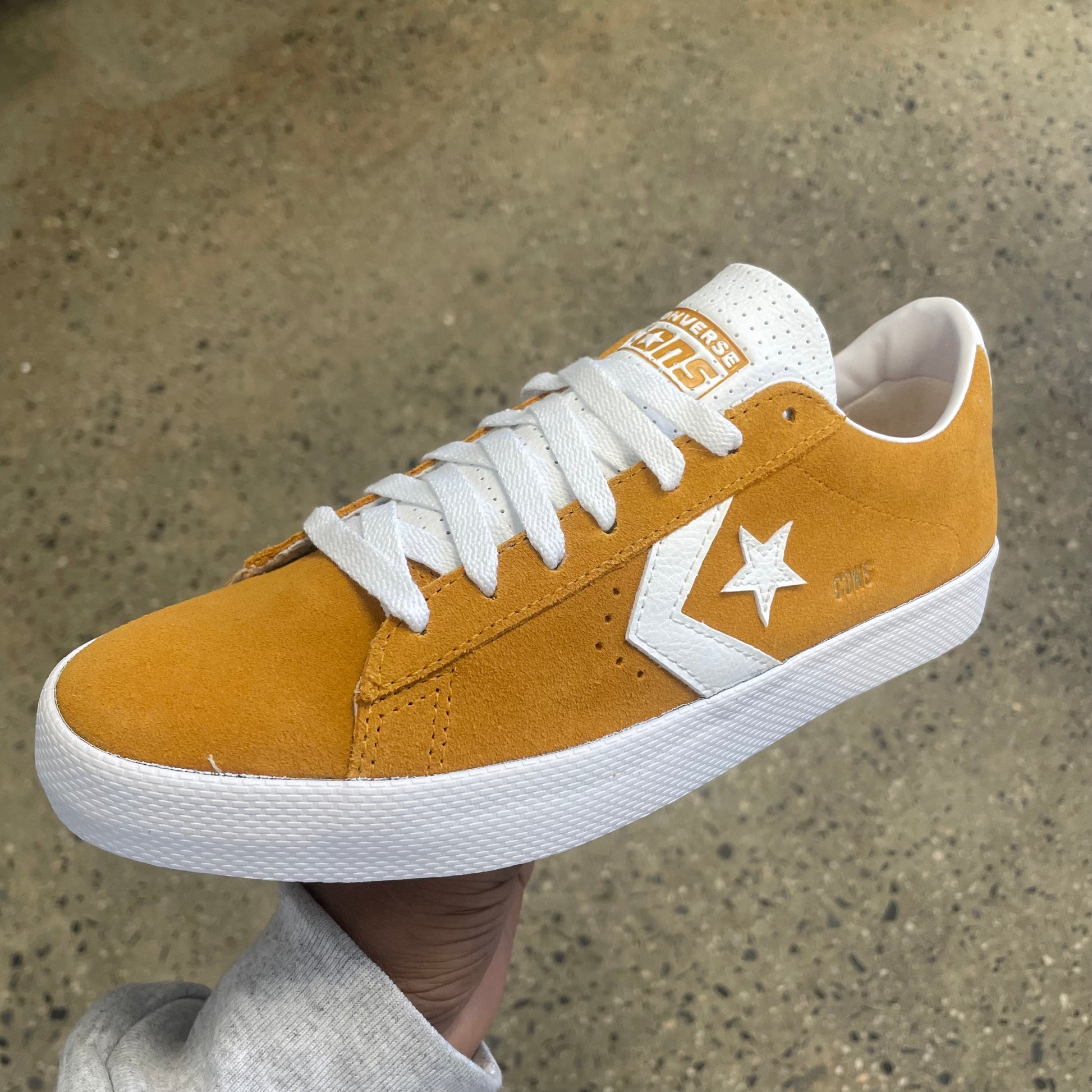 gold suede sneaker with white stripe, star, and sole, side view