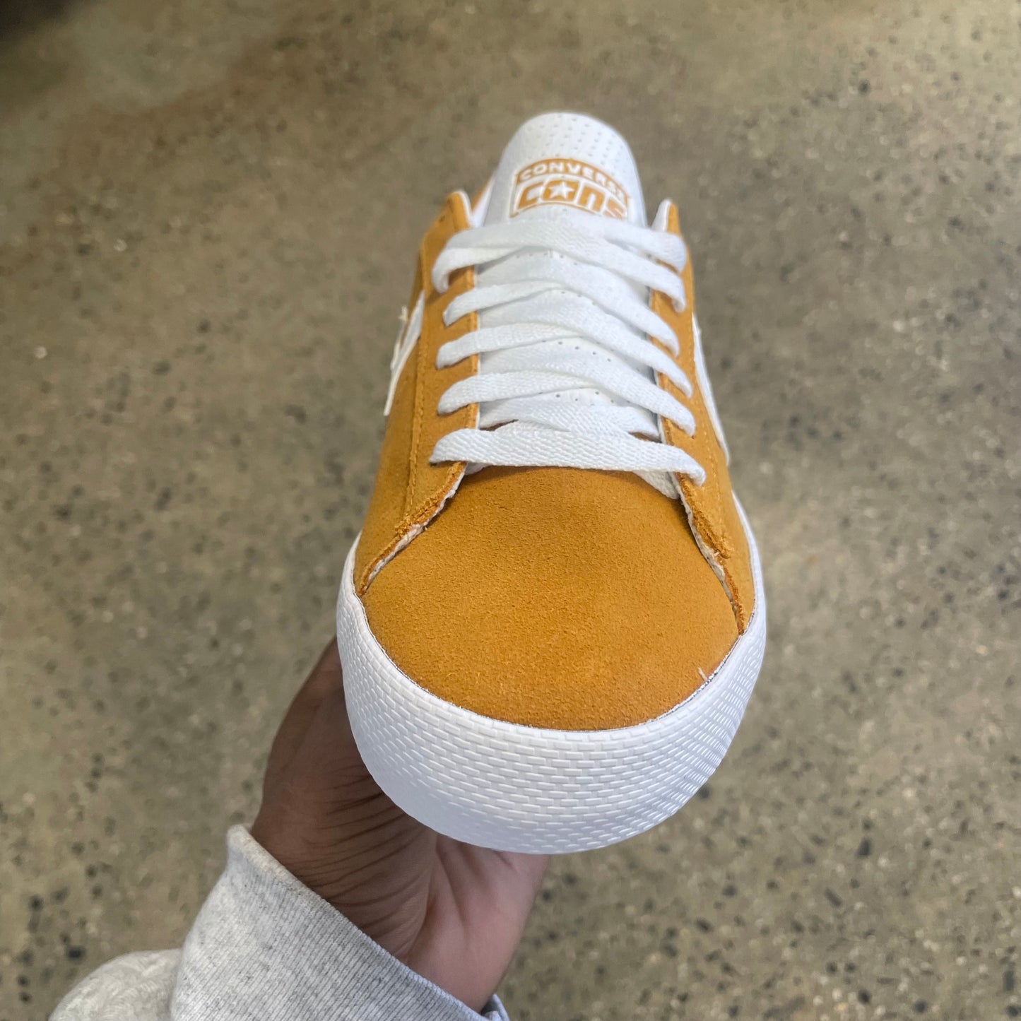 gold suede sneaker with white stripe, star, and sole, front view