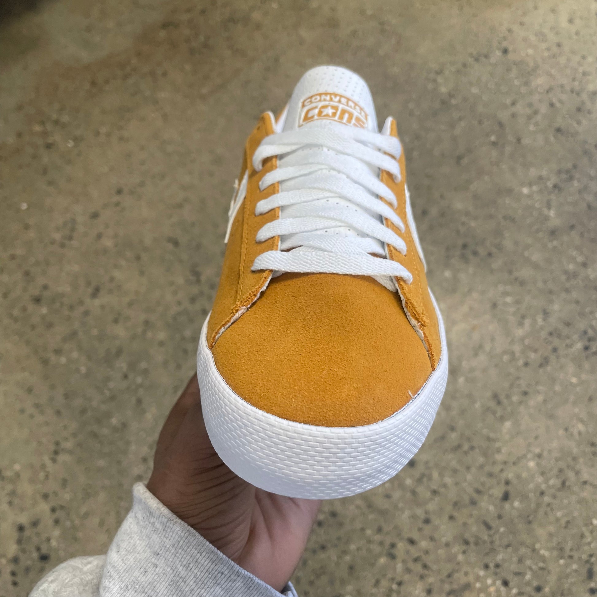 gold suede sneaker with white stripe, star, and sole, front view
