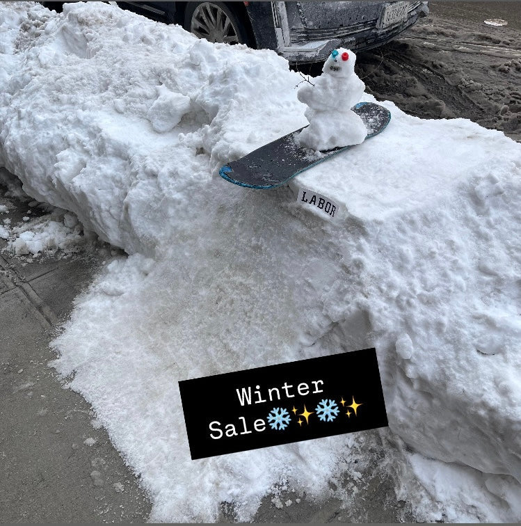 mini snowman on a skateboard deck on top of a snow skate ramp