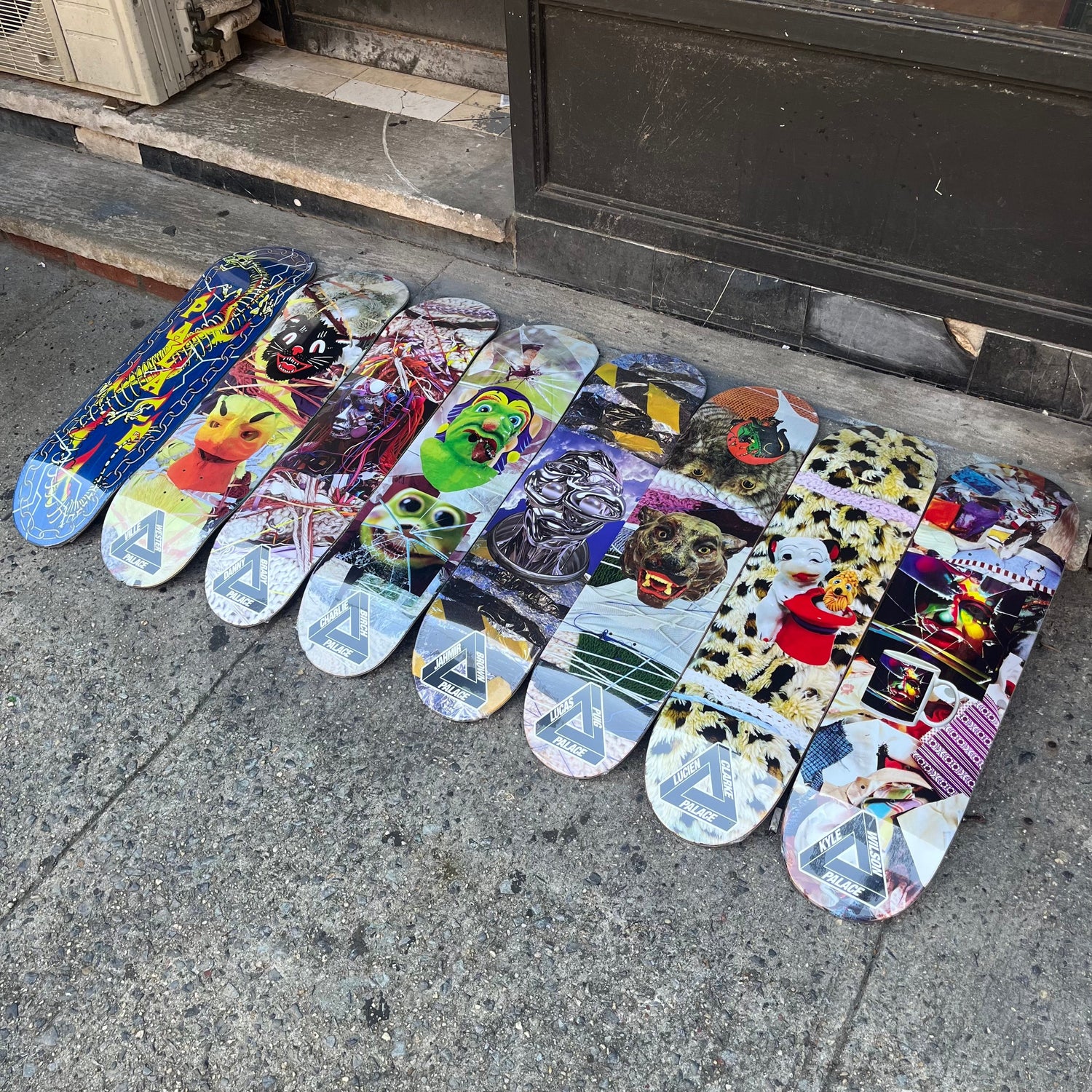 assorted multicoloe graphic design looking skateboards against a sidewalk 