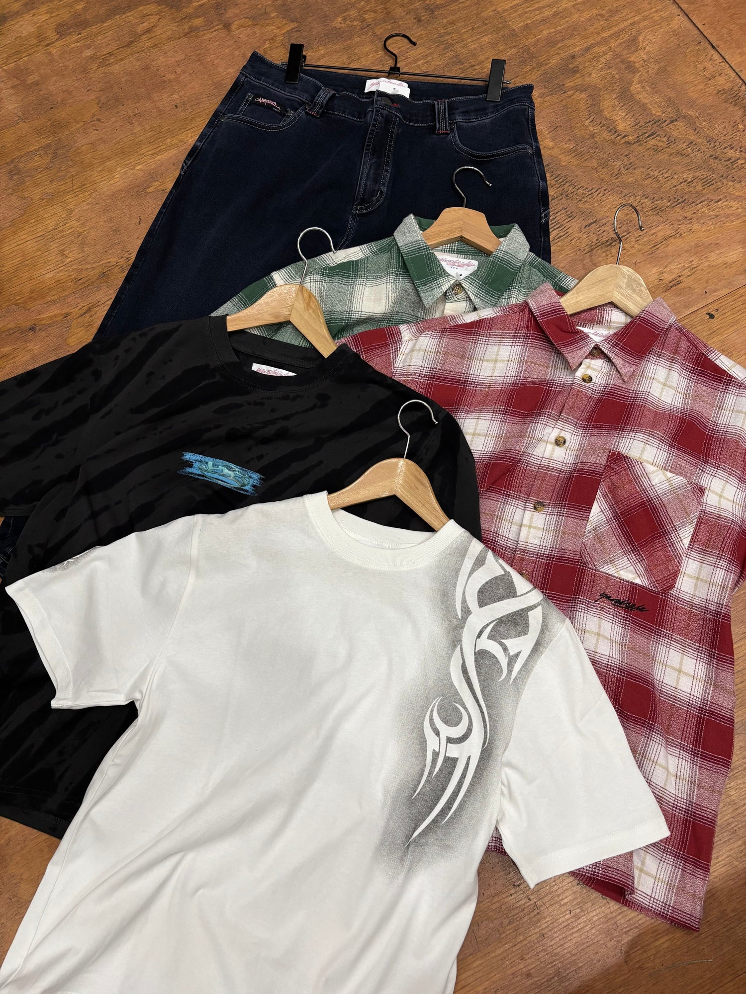 assorted yardsale apparel items on a wood floor