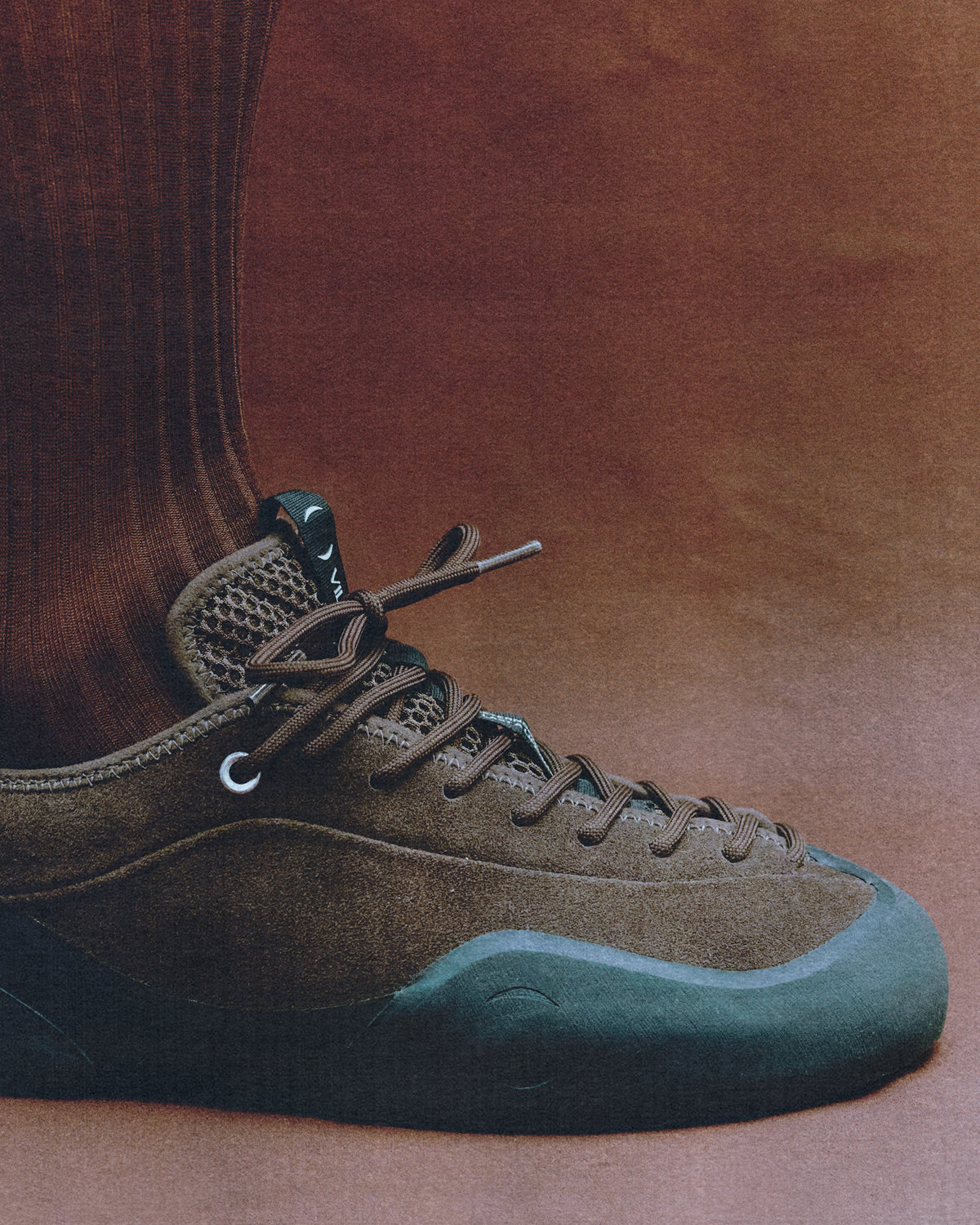 foot and shin with brown sock, wearing brown village PM sneaker