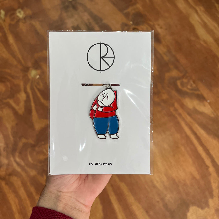 Keychain of a person with a red top and blue pants
