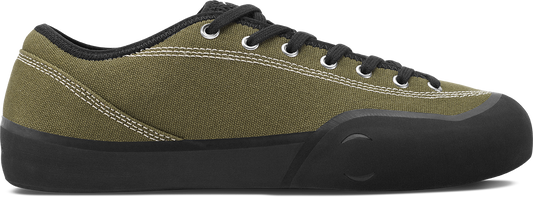 An olive green canvas low-top sneaker with black laces, a black collar, and a black rubber sole, shown from a side profile on a white background.