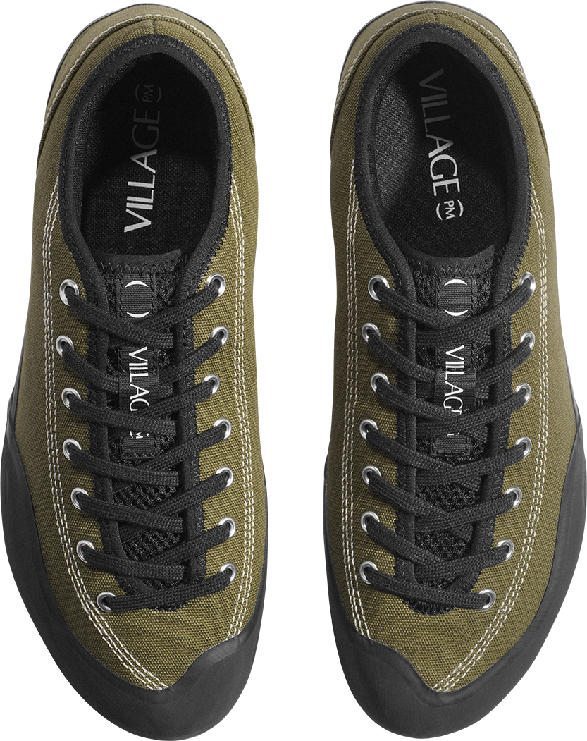 A pair of low-top canvas sneakers shown from a top-down view. The uppers are olive green canvas with black laces, black mesh lining, black rubber soles, and silver metal eyelets.