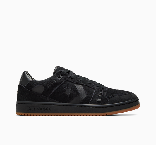 Side view of all black suede lowtop sneaker with gum sole on the bottom of shoe