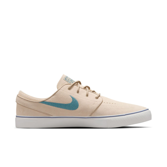 side view of cream colored low top suede skateboard shoe with white sole and light blue swoosh