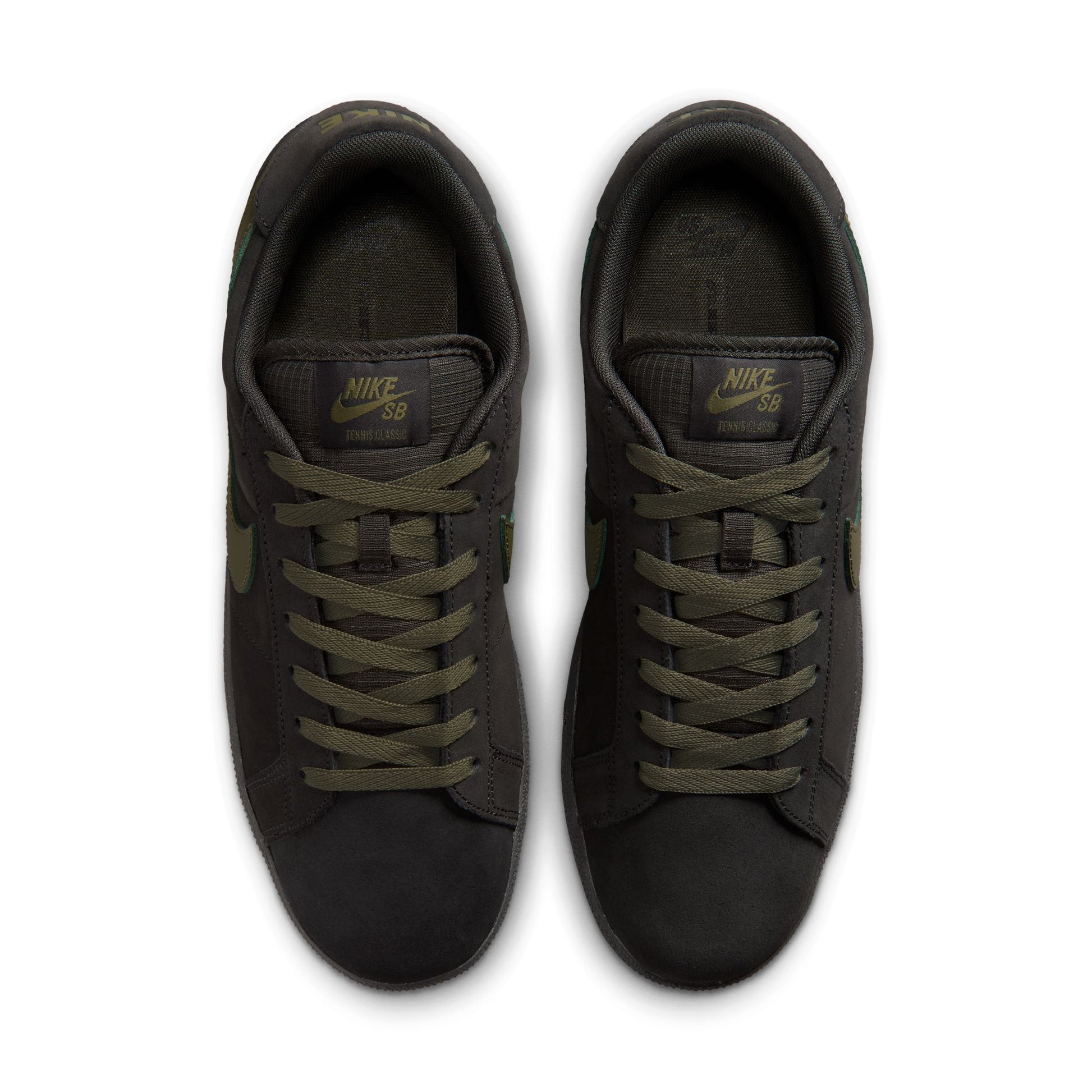 Pair of black Nike sneakers with green laces on a white background