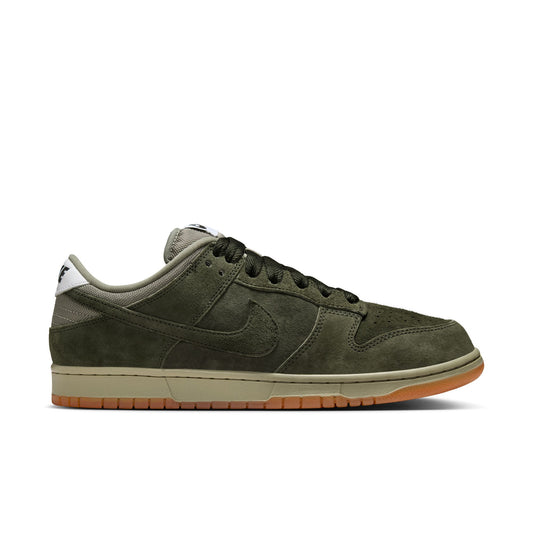 Green sneaker with a brown sole on a white background