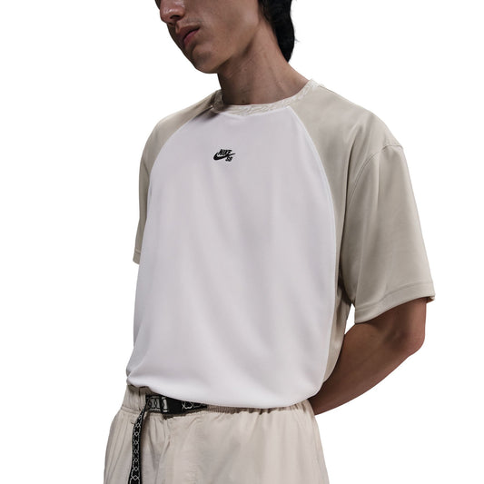 model wearing white and tan nike sb dry fit jersey