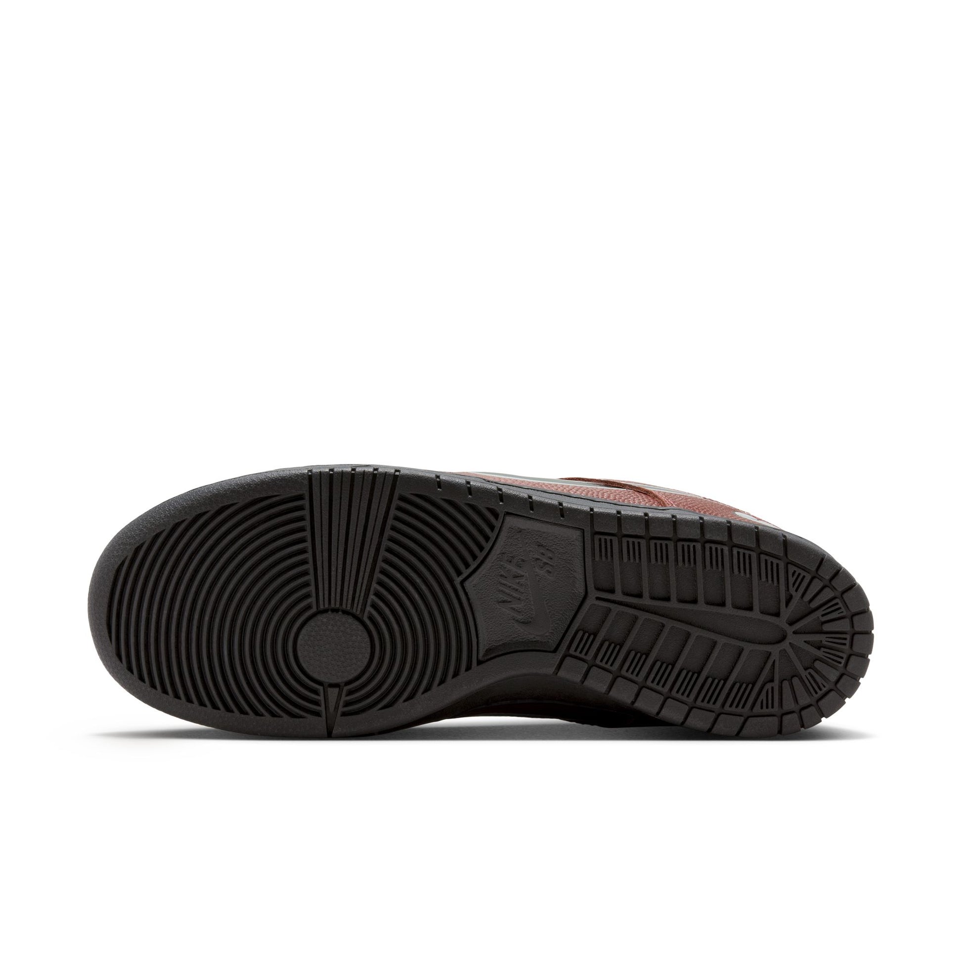 Close-up of a brown shoe sole with black tread pattern on a white background
