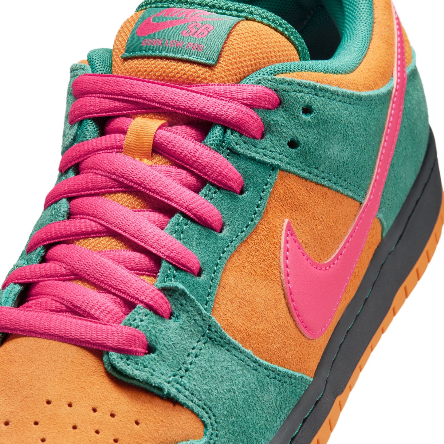 Colorful sneaker with pink laces and a green and orange design on a white background