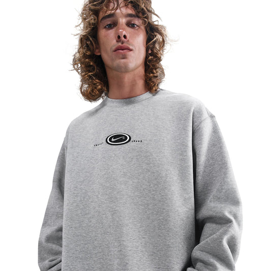 Person wearing a gray sweatshirt with a logo on a white background