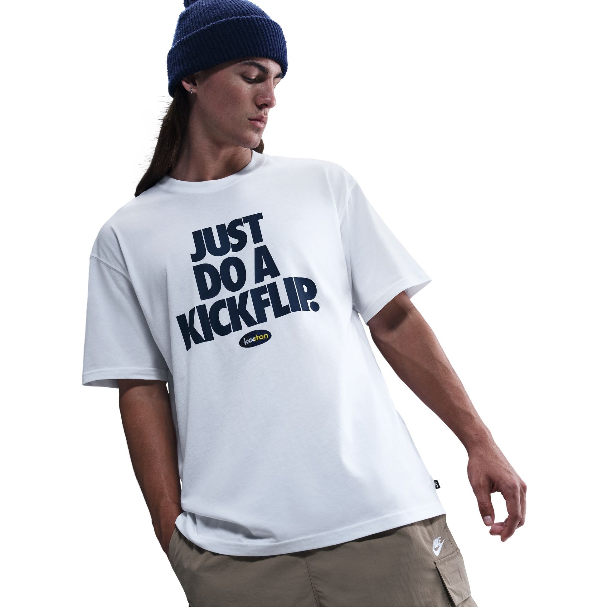Person wearing a white t-shirt with 'Just Do A Kickflip' text and a blue beanie on a white background
