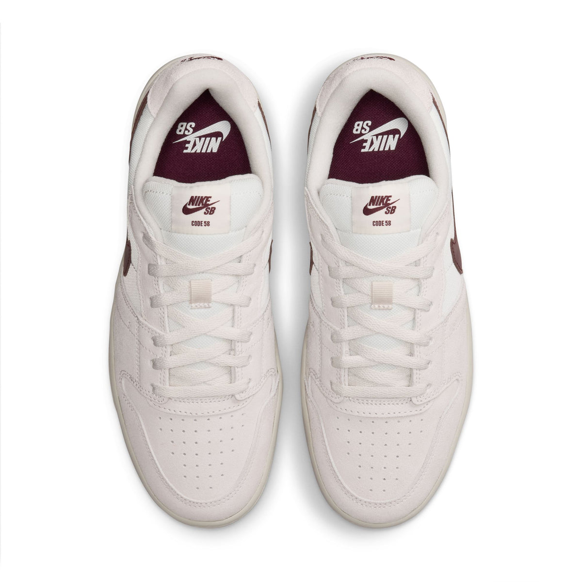 A pair of Nike SB sneaker low-top shoes shown from a top-down view on a white background. The shoes are primarily off-white with a deep burgundy/maroon Nike SB logo on the tongue and heel.