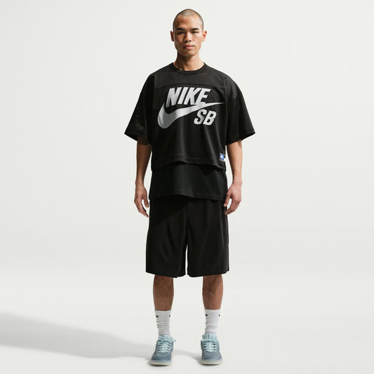 Person wearing a black Nike SB t-shirt and shorts on a white background