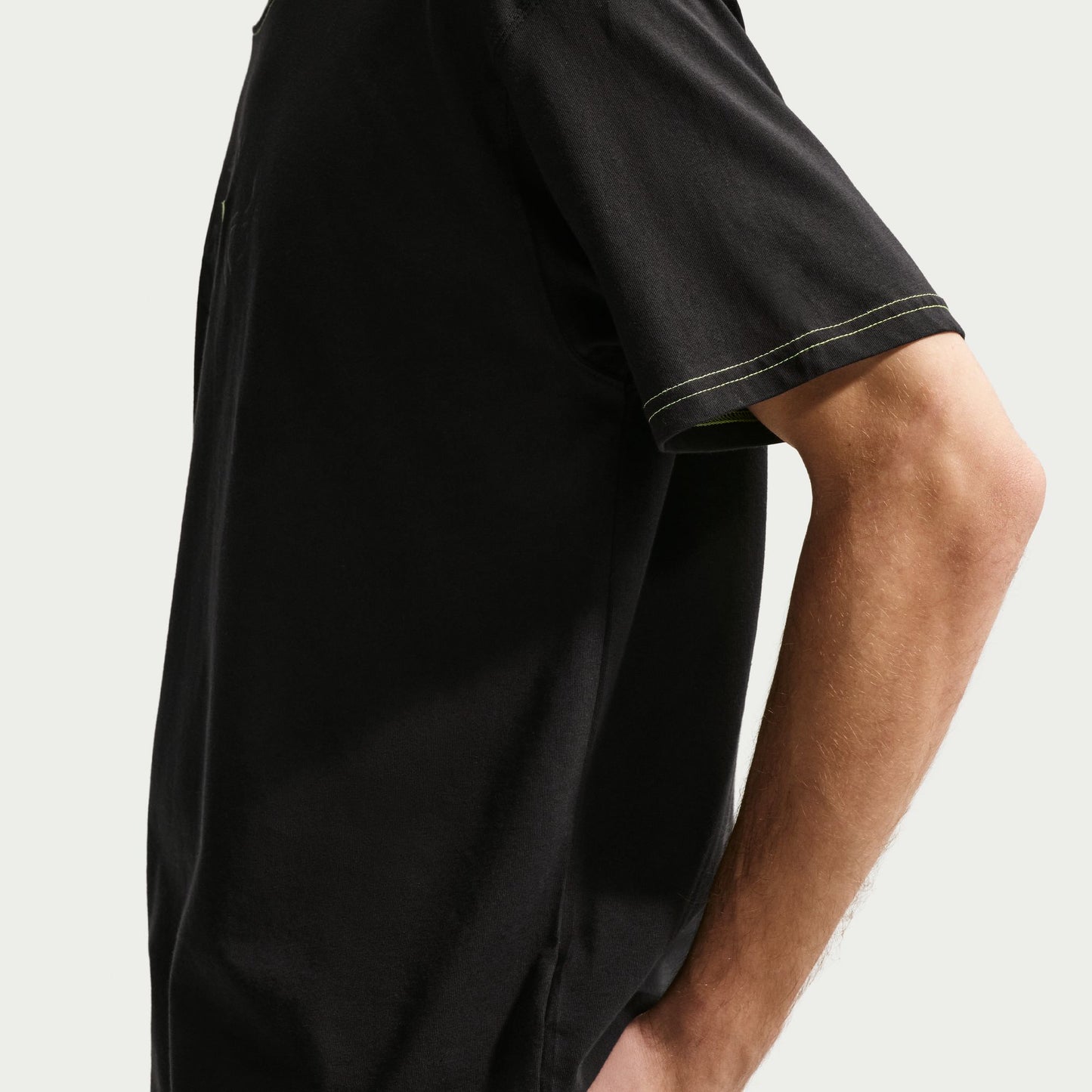 Black t-shirt worn by a person on a light gray background