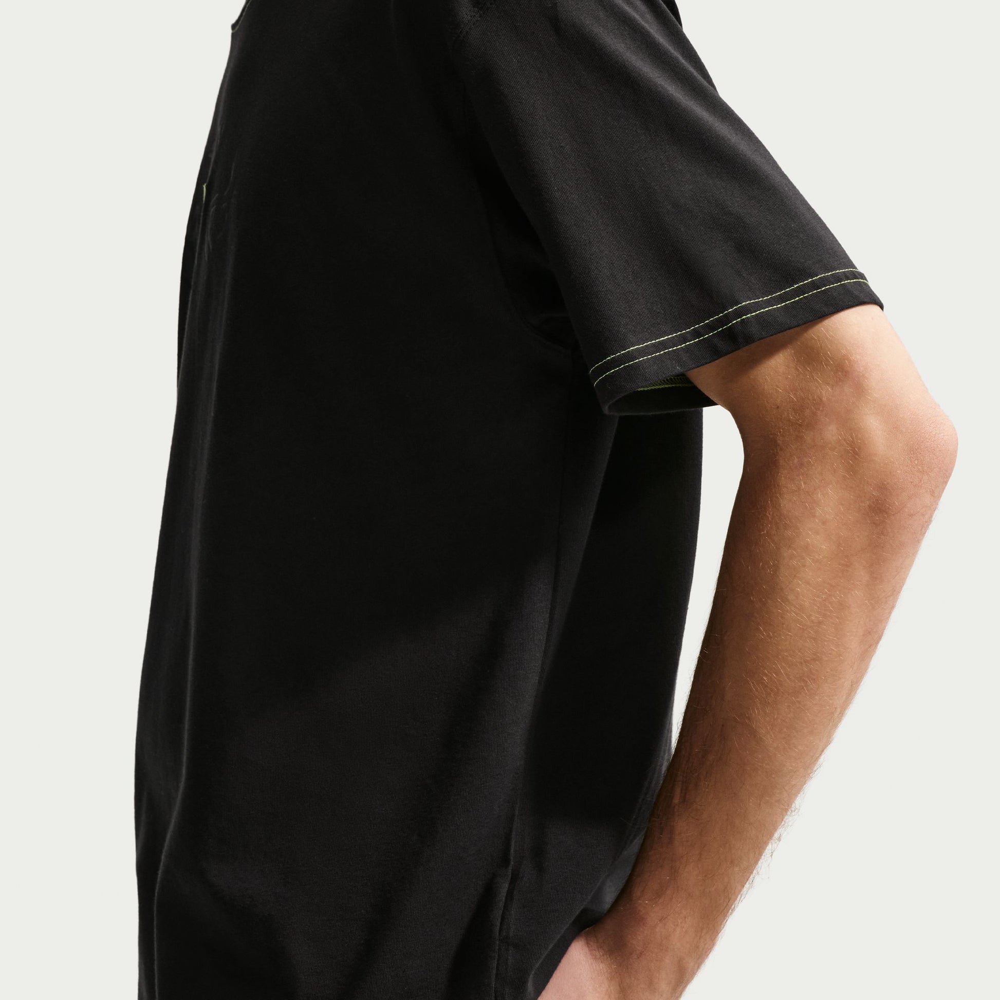 Black t-shirt worn by a person on a light gray background