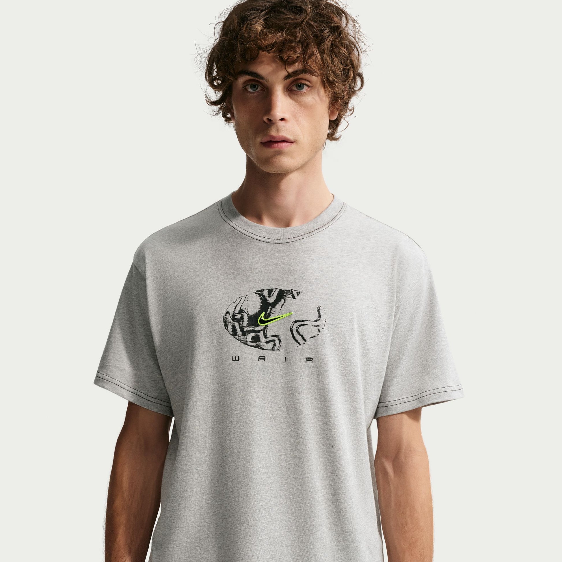 Person wearing a gray t-shirt with a logo on a white background